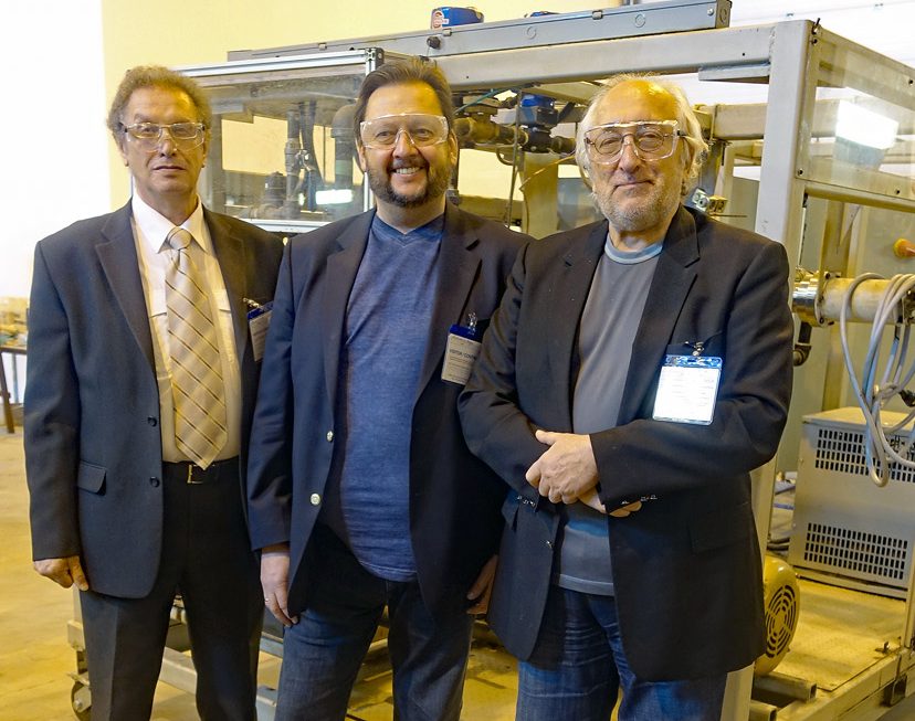 Three members of the EIREX team in safety glasses in front of a cavitation prototype rig